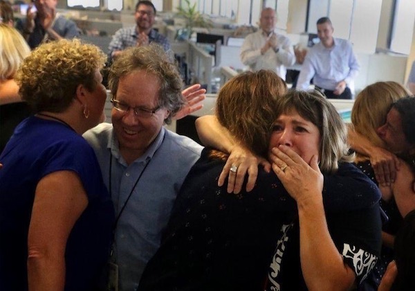 David Fleshler and colleagues react to news of their winning the Pulitzer Prize Monday in the Sun-Sentinel newsroom. Photo: Carline Jean/El Sentinel